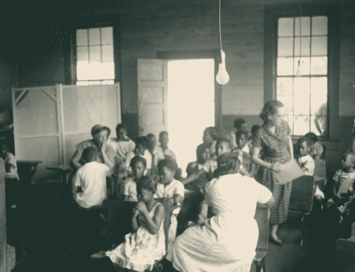 Students seated together at desks in a classroom, photographed in 1953.